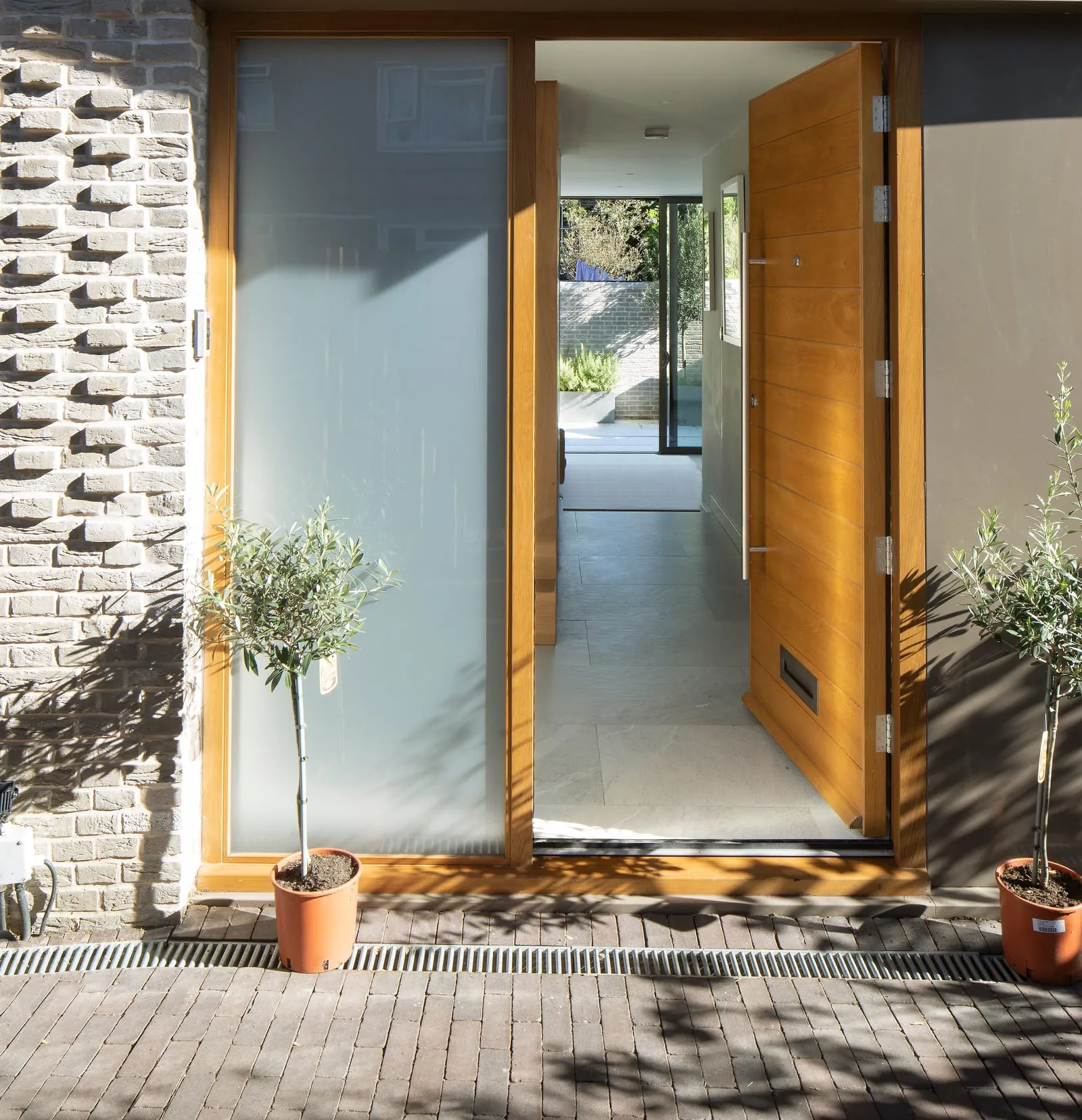 Oak front door with olive trees either side
